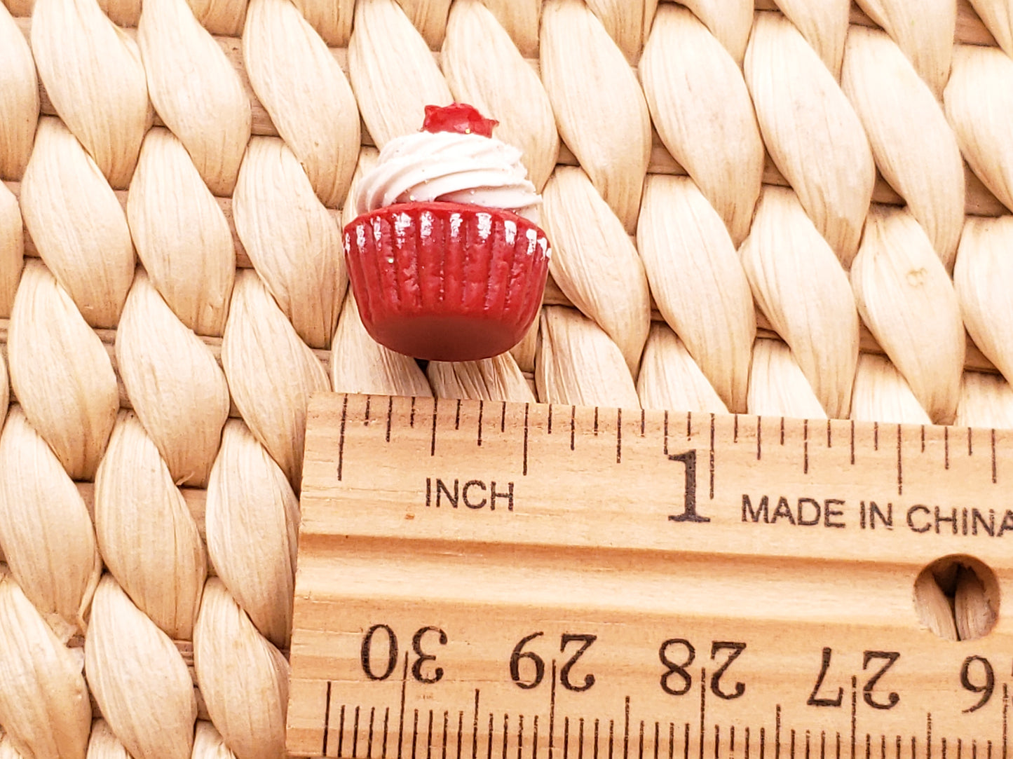 a cupcake sitting on top of a wooden ruler